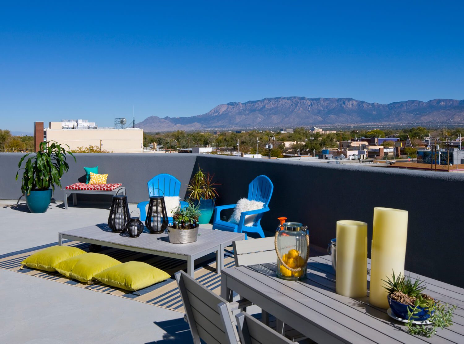 Furnished rooftop patio with mountains in the distant sky
